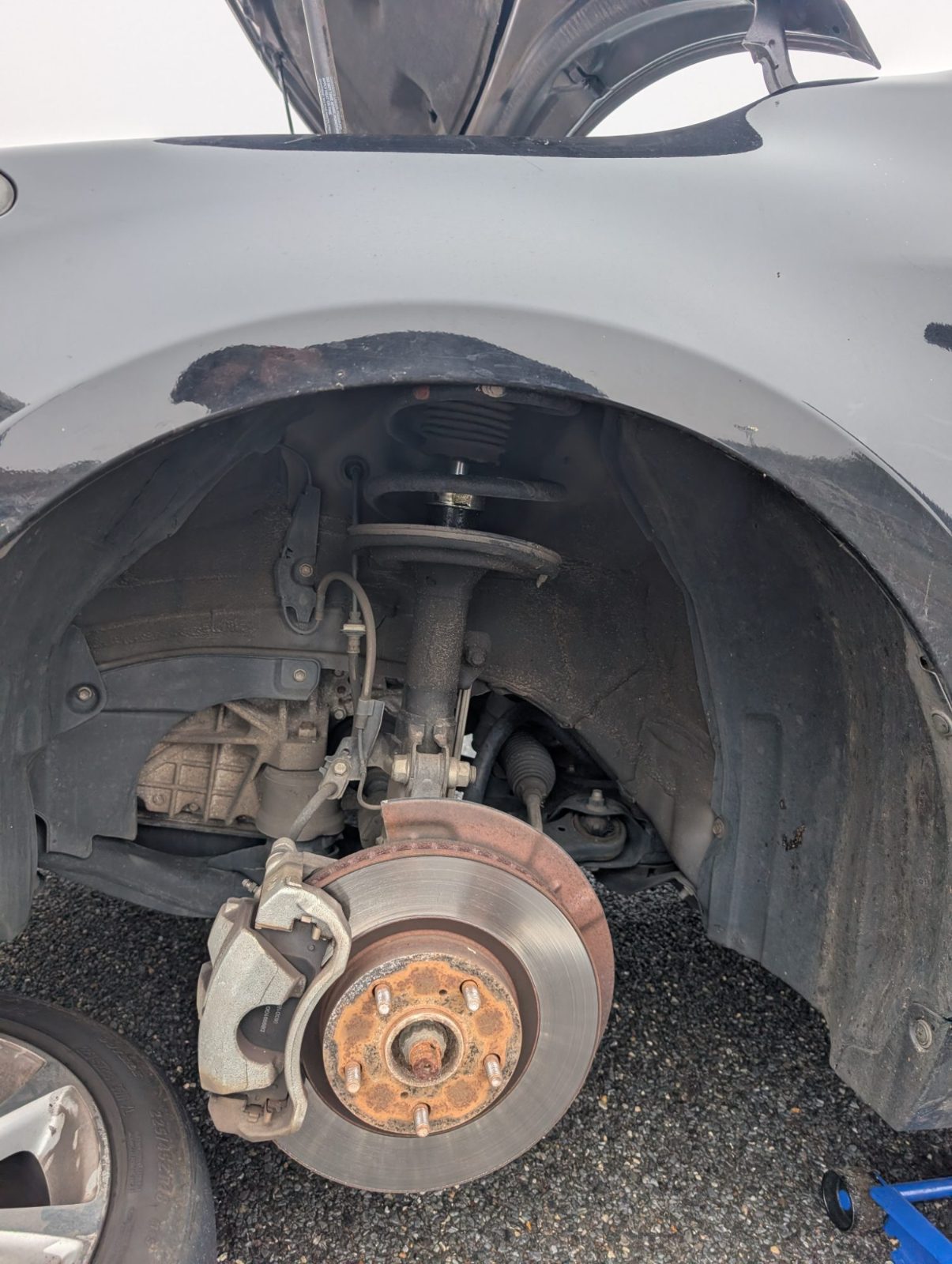 Wheel removed to show the front suspension, coil spring, brake rotor and caliper